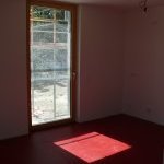 ein Sonnenfleck auf rotem Boden einer Wohnung